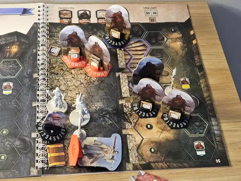 A tabletop game board with hexagonal tiles, monster tokens, and player pieces. Multiple identical 'Blood Monstrosity' tokens…