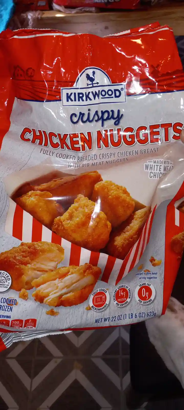 A close-up photo of a red and white Kirkwood brand bag of crispy chicken nuggets, showing the product image, nutritional…