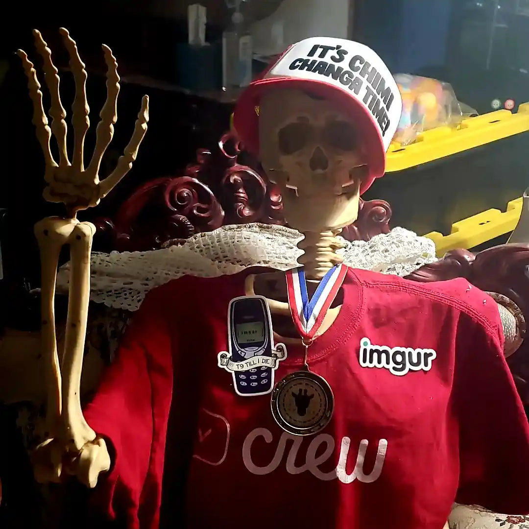 A skeleton wearing a red and white cap that reads 'IT'S CHIMI CHANGA TIME!' and a red shirt with 'imgur' and 'crew' logos…