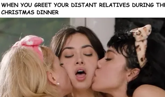 A woman with dark hair and closed eyes has her mouth open as two other women, one with blonde hair and a pink bow, the other…