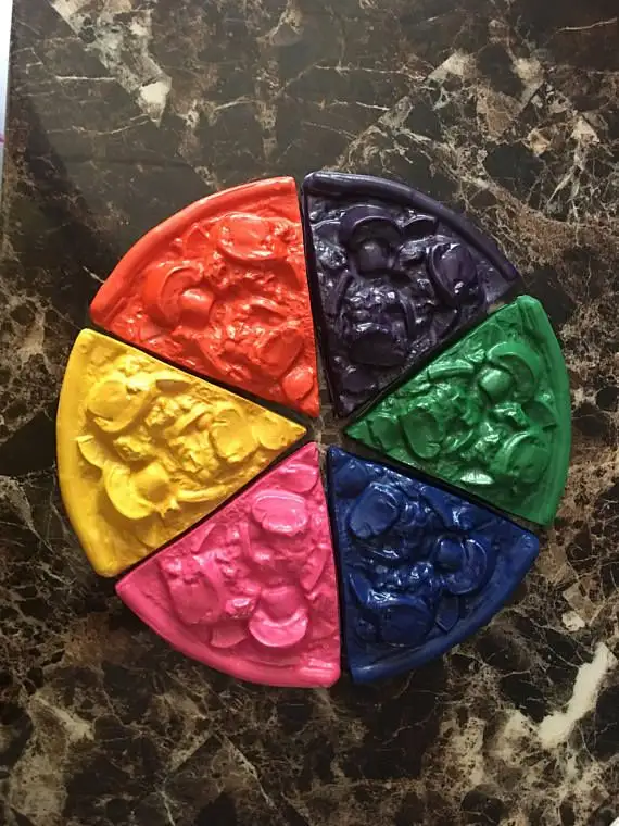 a circular arrangement of six pizza slices, each a different vibrant color of paint (red, orange, yellow, pink, blue, green…