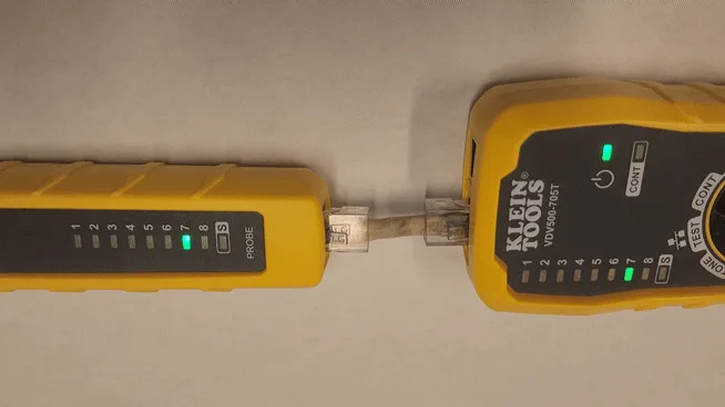 two rows of identical yellow Klein Tools network cable testers connected in a chain, each showing green lights on different…