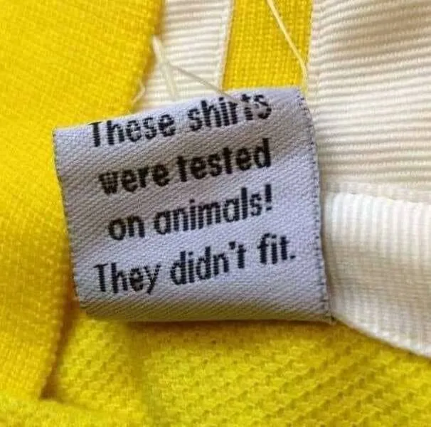 A close-up of a clothing tag sewn onto a yellow and white garment, which reads 'These shirts were tested on animals! They…