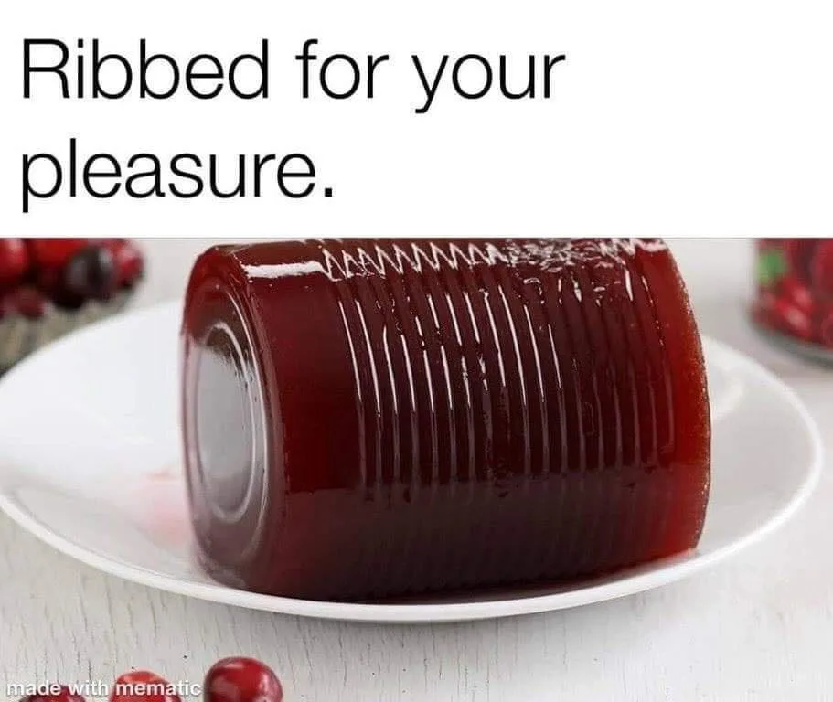 A glossy, dark red cranberry sauce sits on a white plate, its surface imprinted with distinct vertical ridges from having…