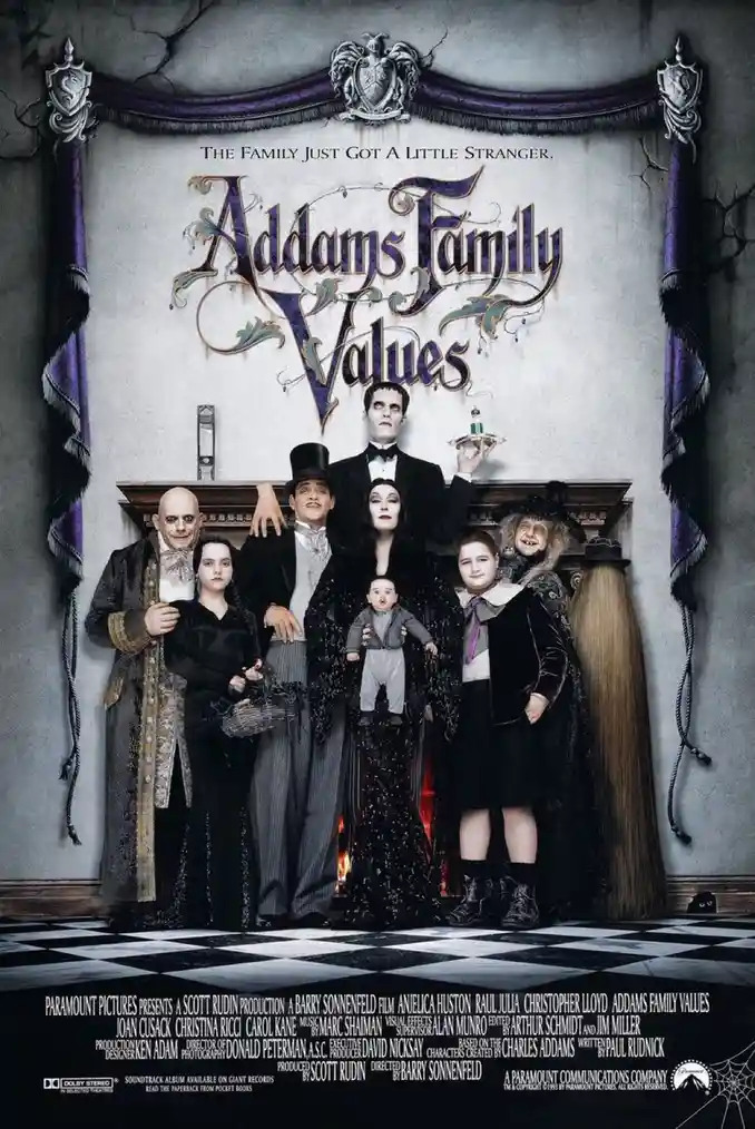 A movie poster for 'Addams Family Values' shows the Addams family posing in front of a fireplace in their gothic mansion…