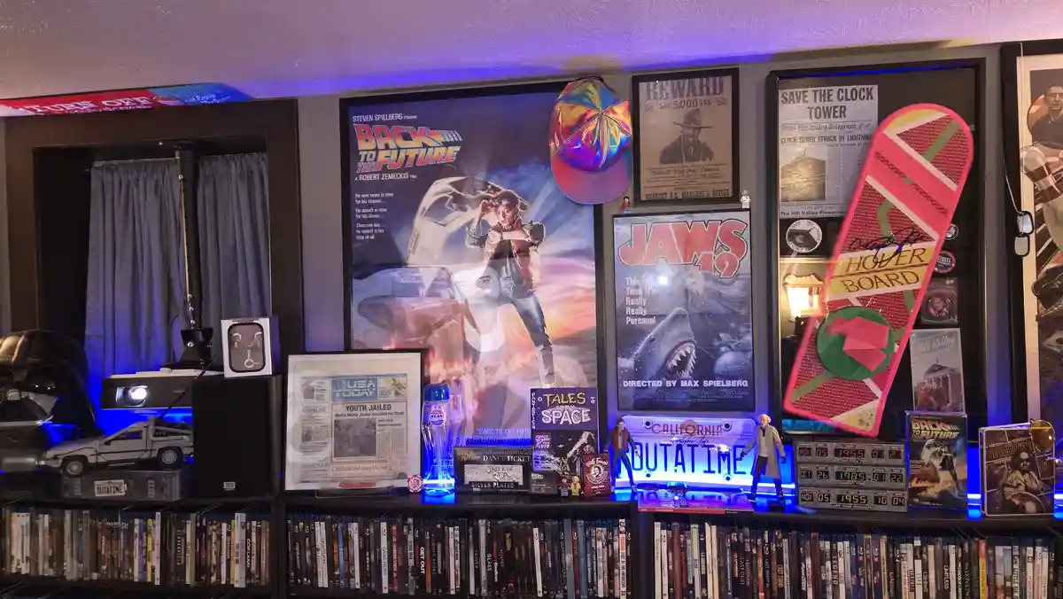 A wall display filled with 'Back to the Future' memorabilia including posters, a hoverboard replica, a DeLorean model, a…