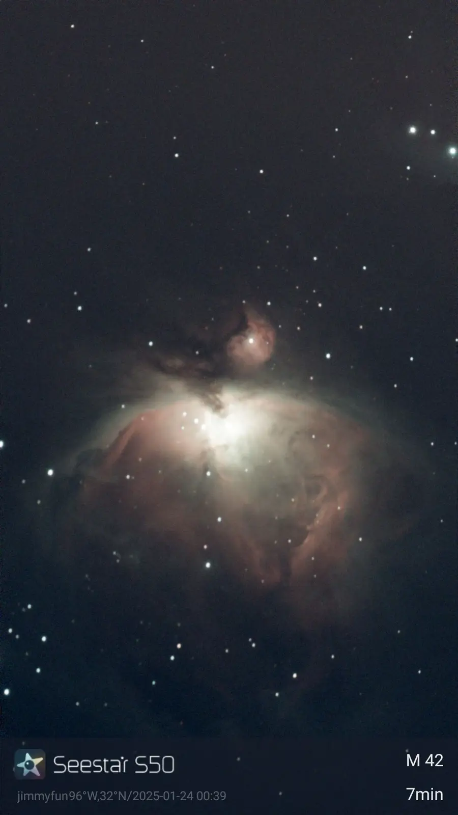 A deep-sky astrophotograph of the Orion Nebula (M42), showing glowing gas clouds and stars against a dark sky. The image has…