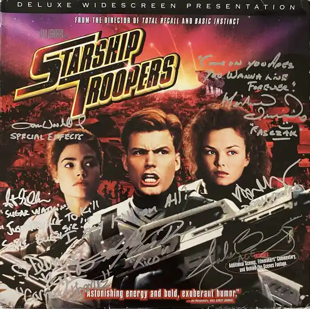 This is a heavily autographed movie poster for 'Starship Troopers' featuring the main cast. The poster's original text is…