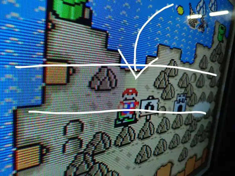 A screenshot of a pixelated video game, likely Super Mario World, shows Mario standing on a rocky terrain holding a sign…