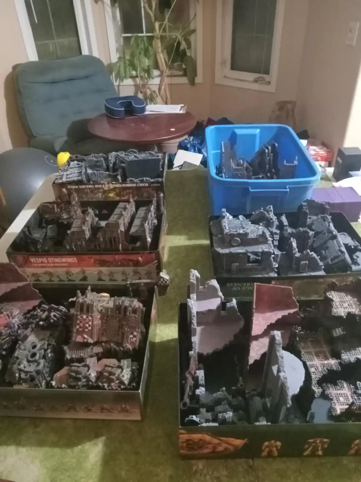 A photo shows several open boxes of Warhammer 40,000 terrain sets, including 'Vespid Stingwings' and 'Age of Darkness'…