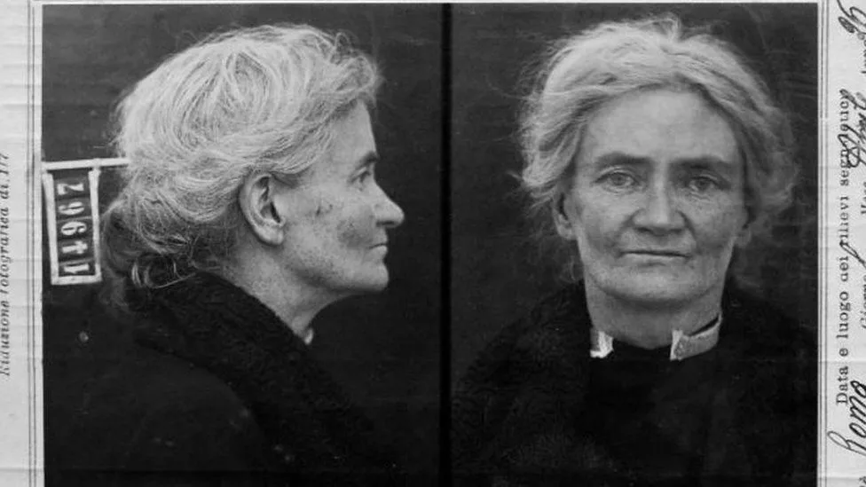 A black-and-white historical mugshot of an older woman with gray hair, shown in profile and frontal views, with Italian text…