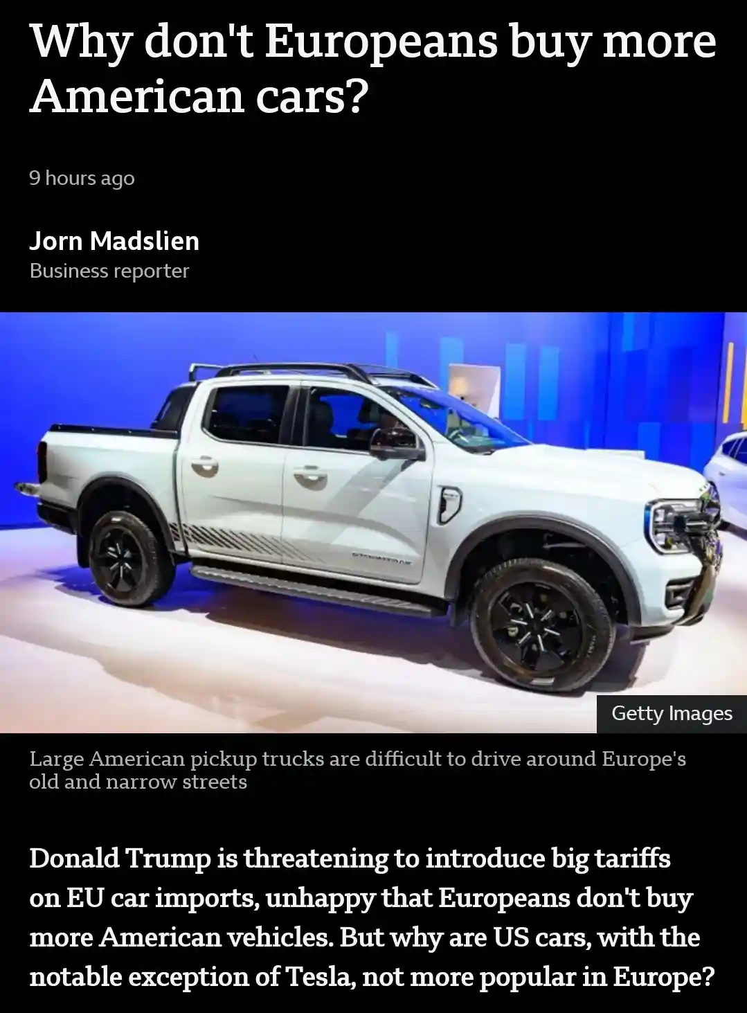 The image displays a white American pickup truck, likely a Ford F-150, on a showroom floor with blue lighting. Overlaid text…