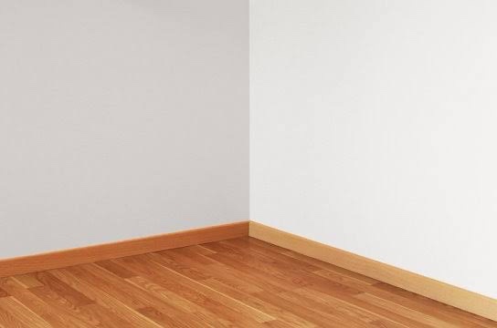 An empty room corner with light wood flooring and white walls meeting at a clean baseboard. Overlaid text reads 'i'm not…