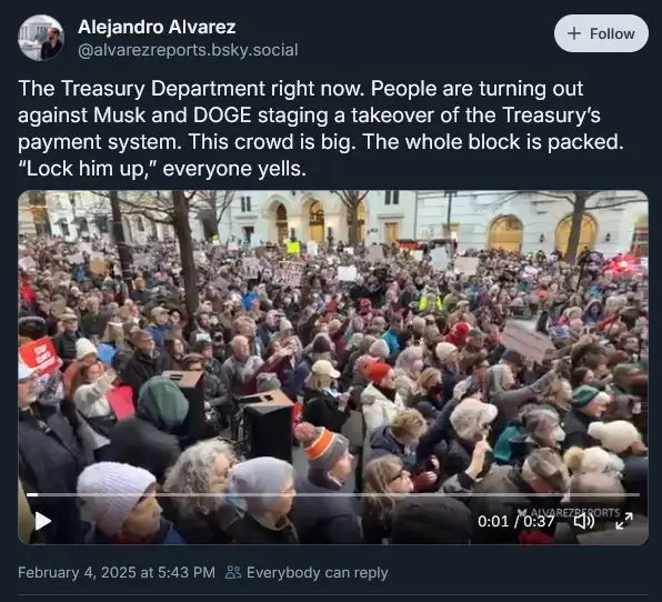 A large crowd of people is gathered in a public square, many holding signs and shouting. The overlaid text reads 'Lock him…