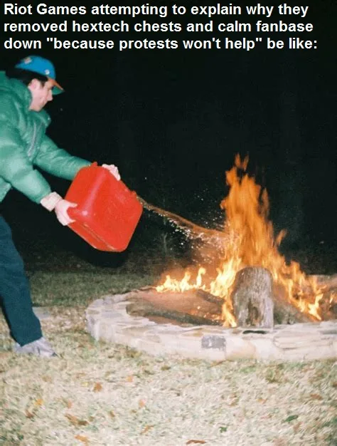 A person in a green jacket and blue cap pours water from a red plastic jug onto a large, roaring campfire in a stone fire…