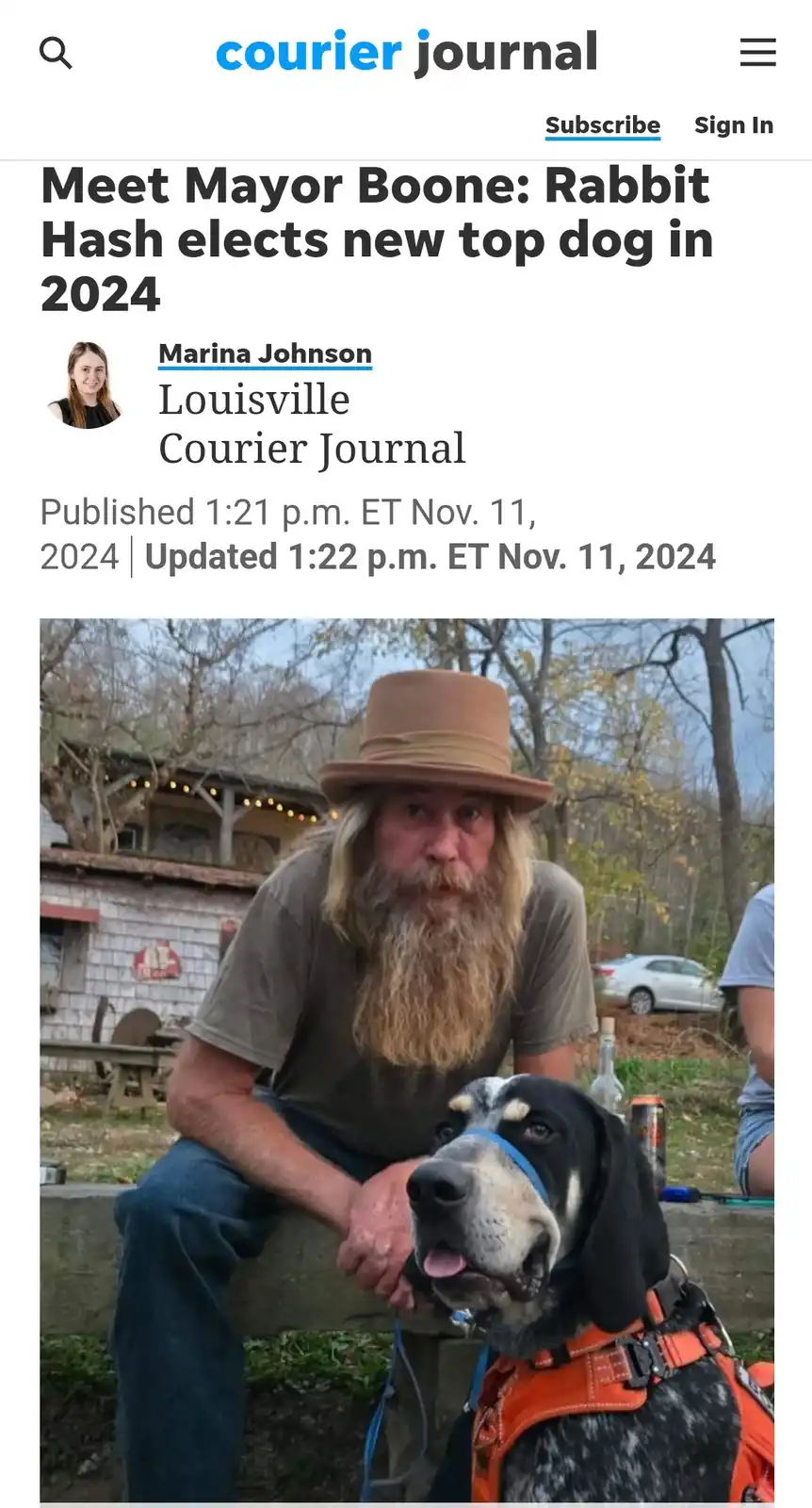 A screenshot of a Courier Journal article shows a man with a long beard and hat sitting beside a black and white dog wearing…