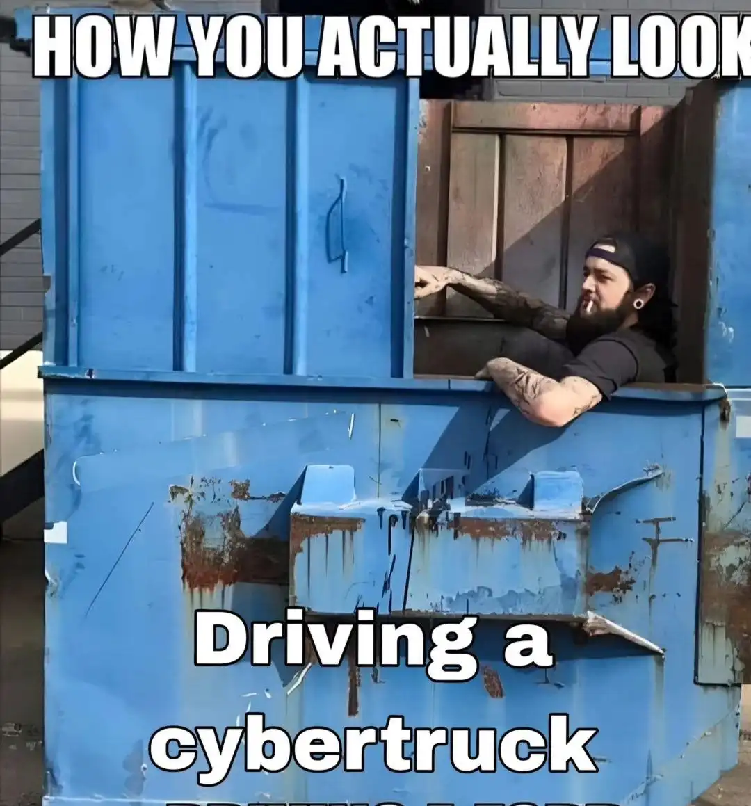 A man with tattoos and a beard, wearing a black cap and shirt, leans out of a large, rusty blue dumpster. The text overlaid…
