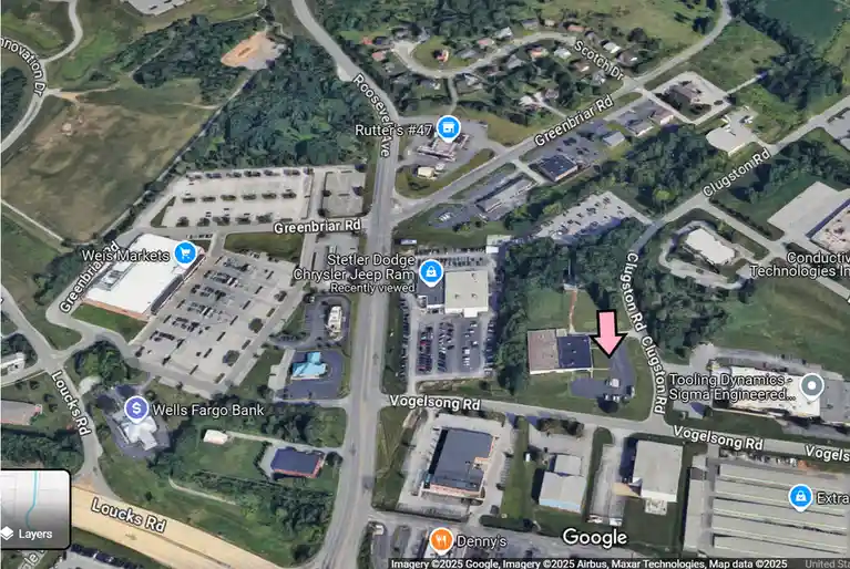 A Google Maps satellite view shows a small building near Clugston Rd with a large pink arrow pointing directly at it…