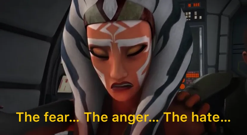 A close-up of the animated character Ahsoka Tano from Star Wars, her eyes closed and face showing intense emotion, with the…