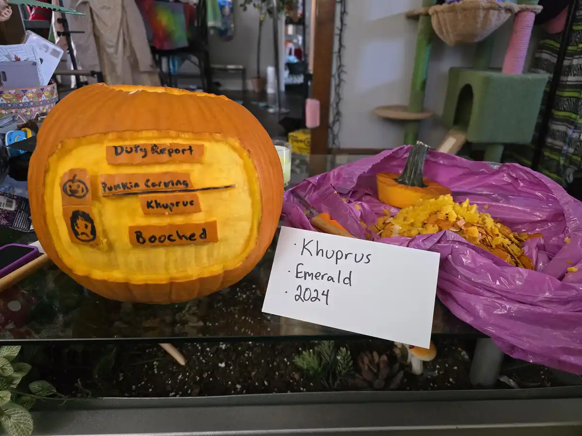 A carved pumpkin with a 'Duty Report' inside, listing 'Punkin Carving' as completed and 'Khuprus' as the person who…