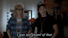 A still from a video shows two people standing side by side in what appears to be a dressing room or backstage area. The…