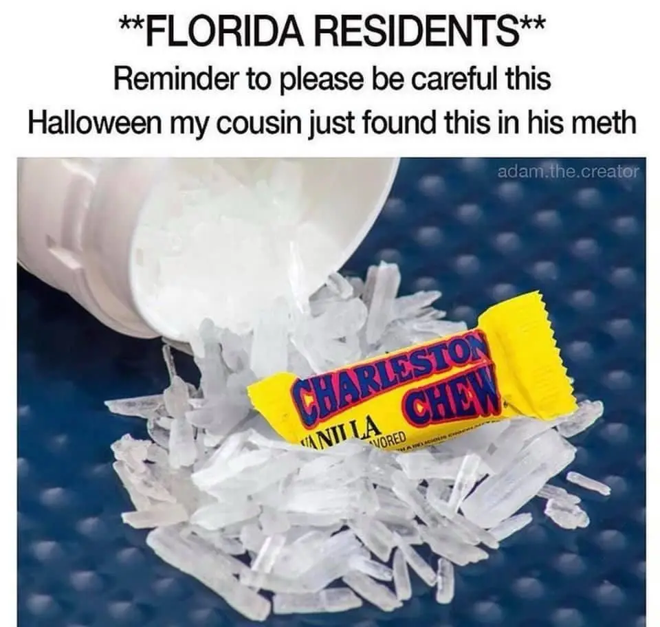 A white pill bottle is tipped over, spilling white crystalline shards onto a blue textured surface. A yellow-wrapped…