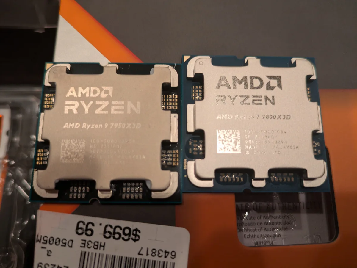Two AMD Ryzen CPUs, a Ryzen 9 7950X3D and a Ryzen 7 9800X3D, are shown side-by-side with a price tag below them reading…