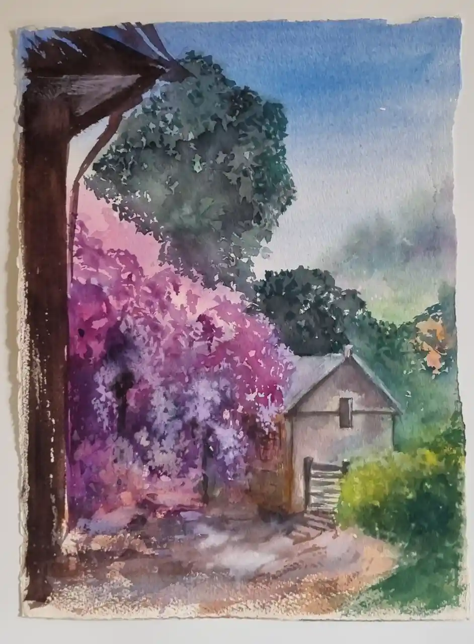 A watercolor painting depicts a rustic scene viewed through a dark wooden frame, featuring a small house, a vibrant purple…