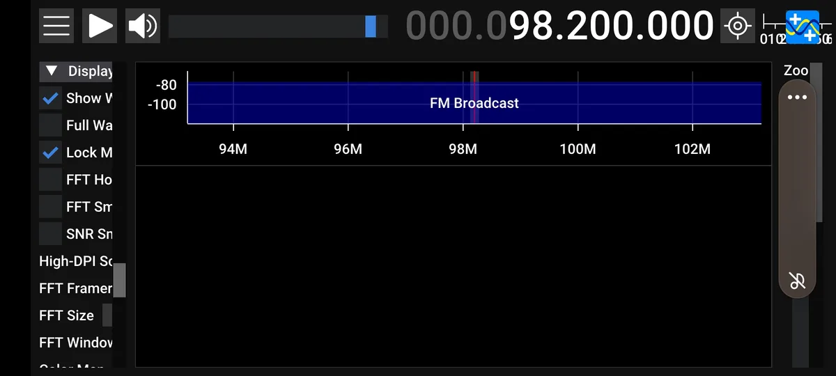 A screenshot of a radio spectrum analyzer app showing a strong signal at 98.2 MHz labeled 'FM Broadcast'. The interface…