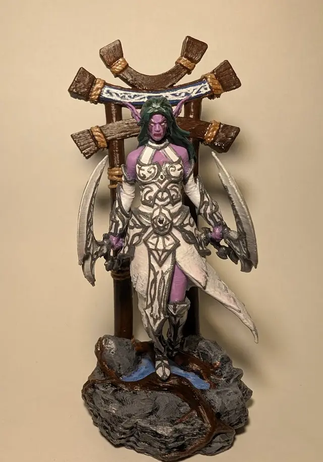 A painted fantasy figurine of a purple-skinned, green-haired elf-like female warrior with pointed ears, wearing ornate white…
