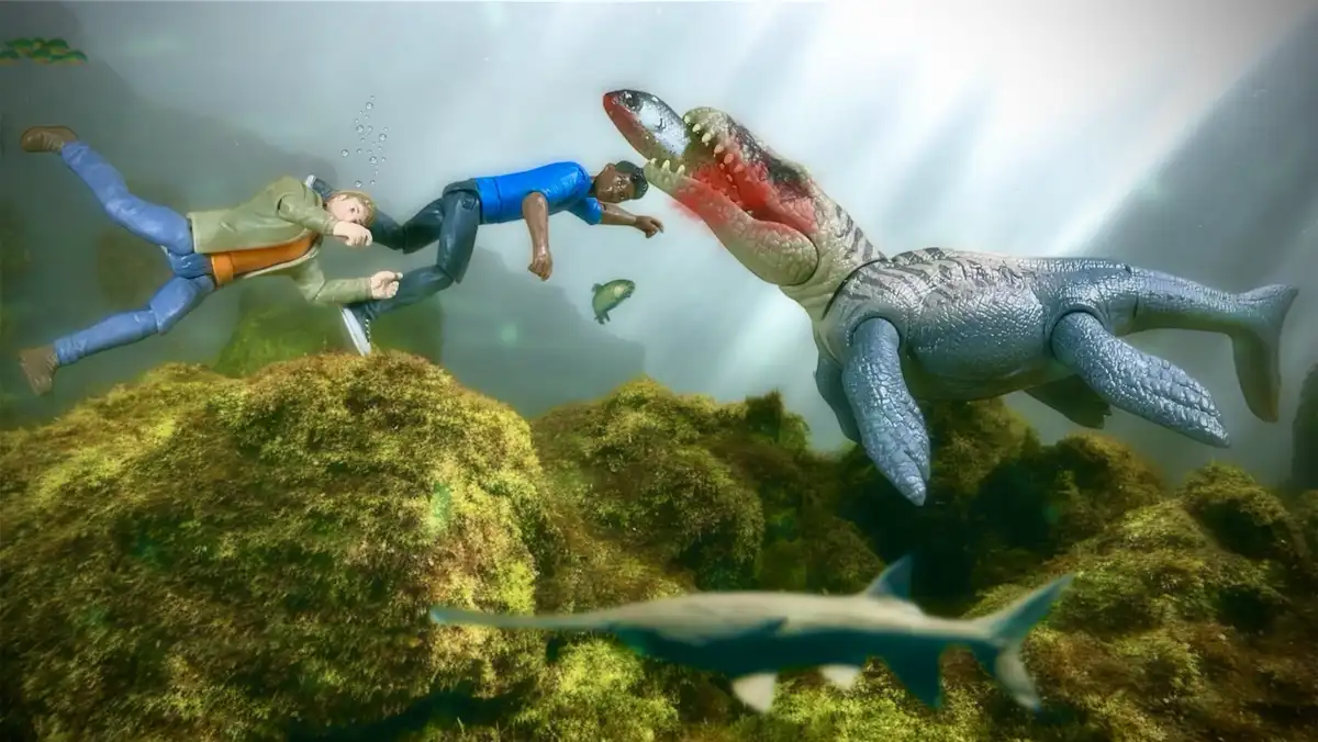 Two action figures, one in a green jacket and one in a blue shirt, are shown underwater, seemingly fleeing from a large…