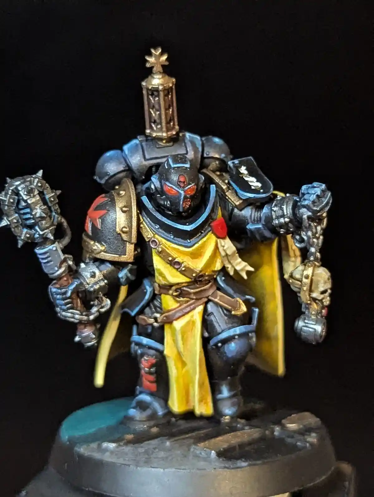 A heavily armored, custom-painted miniature figure resembling a grimdark fantasy warrior stands against a black background…