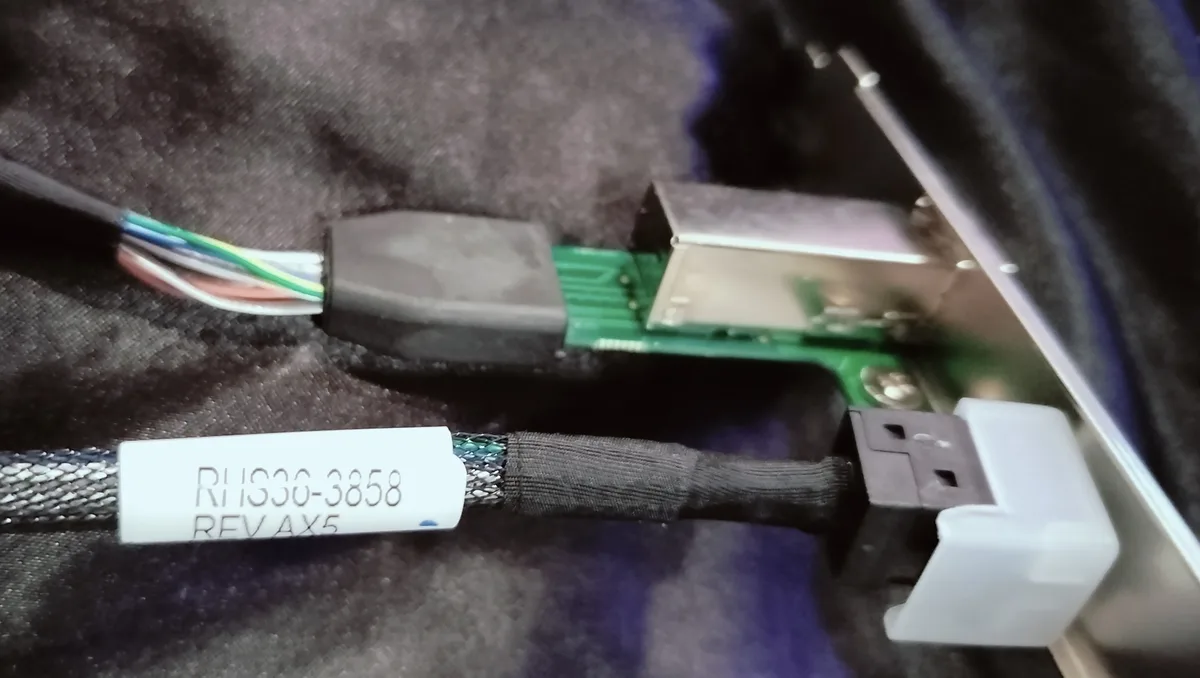 A close-up photo shows a USB cable with a white label reading 'RHIS30-3858 RFV AX5' attached to its braided jacket. The…