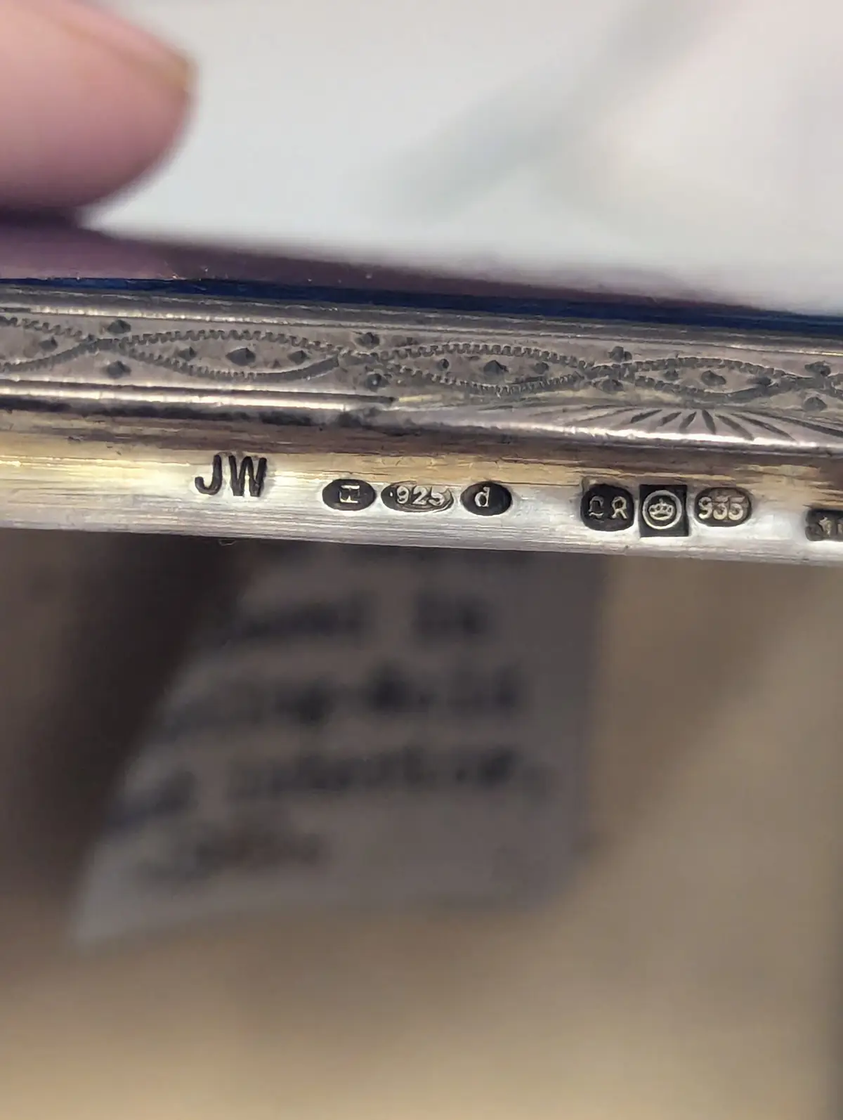 A close-up photo shows the engraved markings on a silver object, including the initials 'JW', a '925' sterling silver…