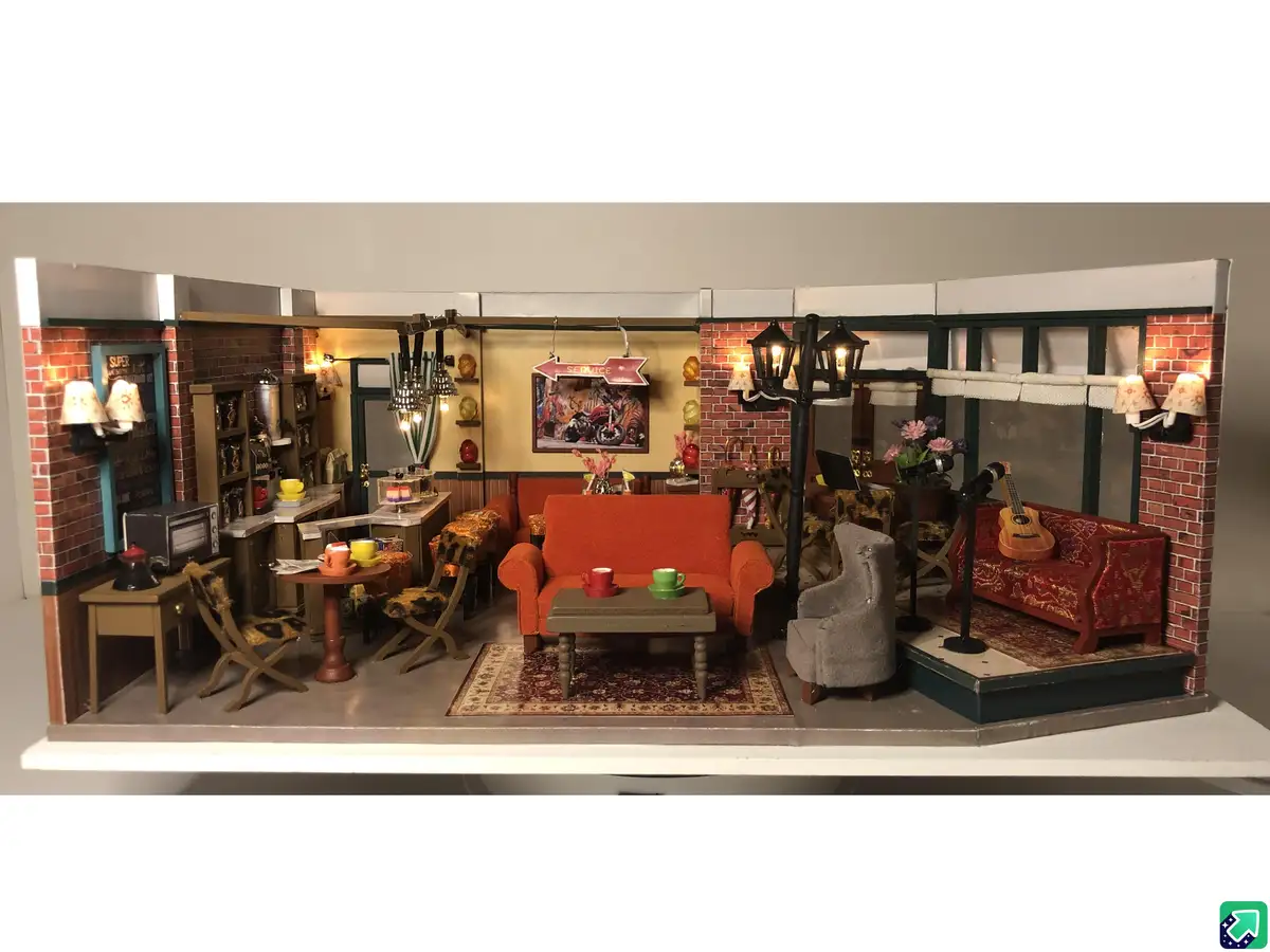 A detailed miniature diorama of the iconic Friends apartment living room, featuring the orange couch, coffee table, red…