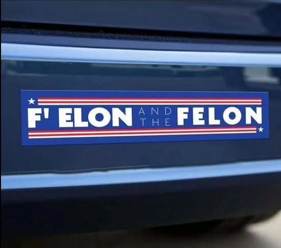 A blue bumper sticker with red and white stripes and stars, reading 'F' ELON AND THE FELON', is affixed to the rear of a…