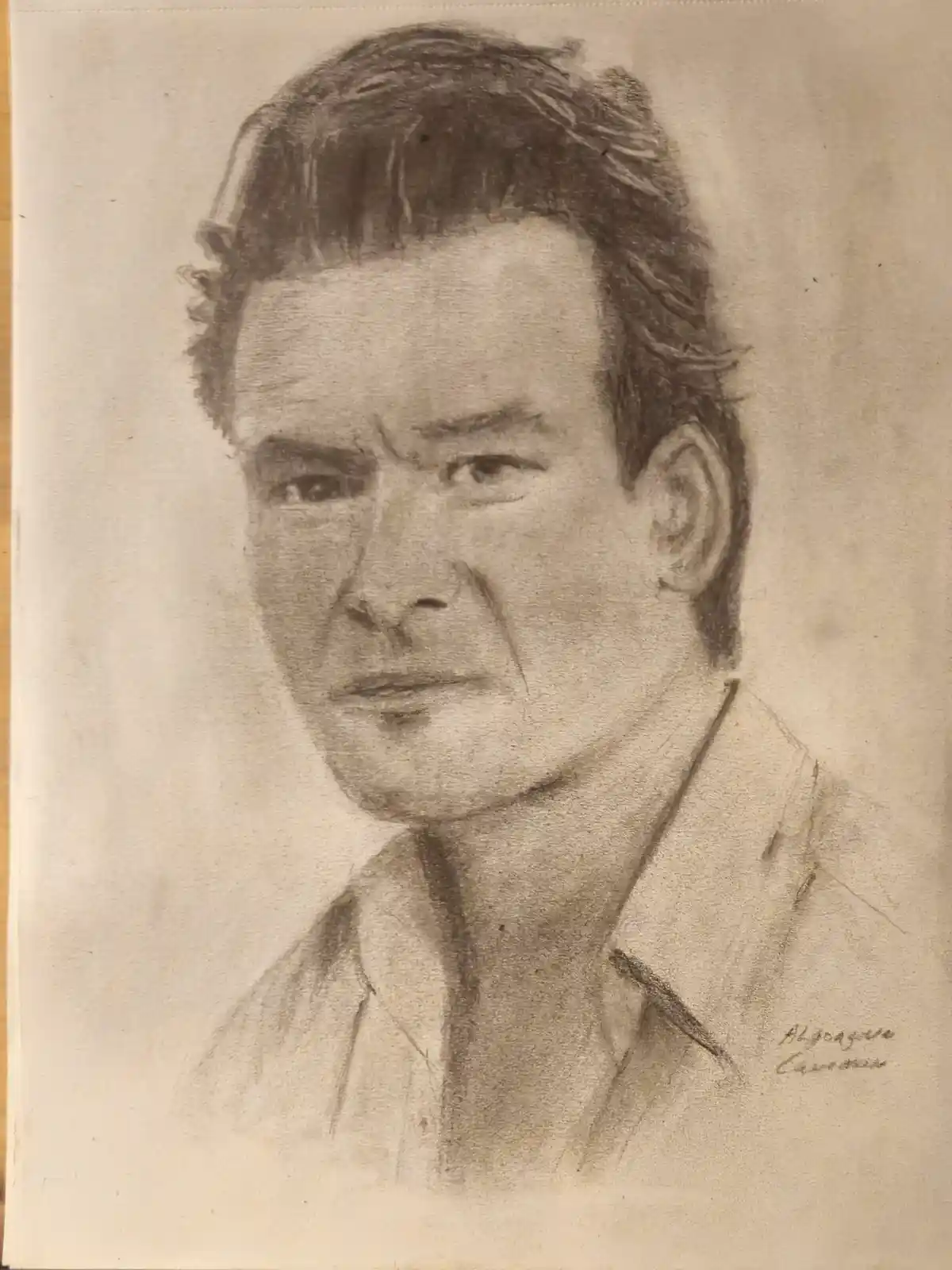 A charcoal sketch of a man with a stern expression, wearing a collared shirt, with the signature 'Algozawa Carvajal' in the…