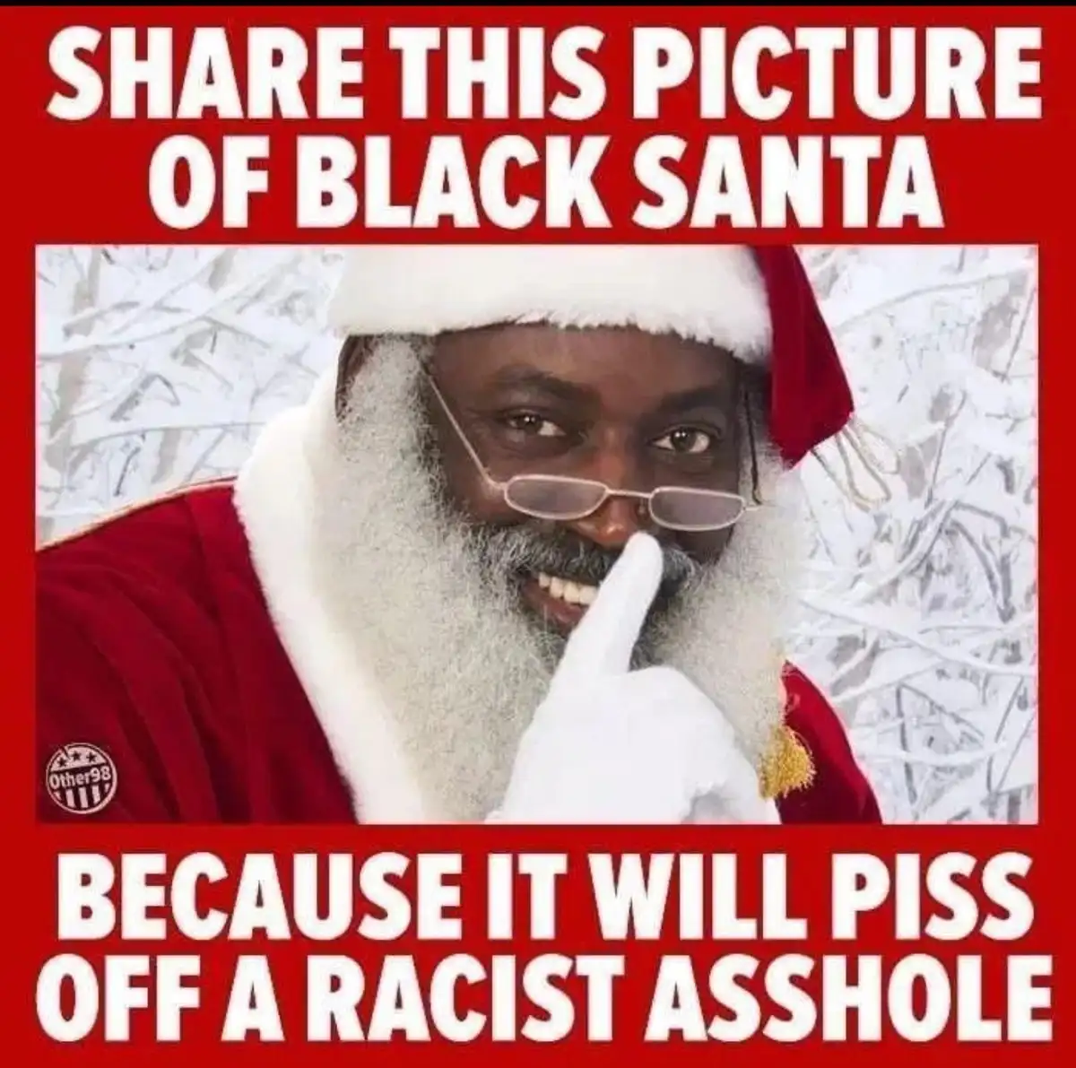 A man with dark skin, wearing a red Santa suit with white trim, a white beard, and glasses, holds up a gloved finger to his…