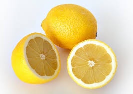 Three lemons are shown against a white background: one whole, one cut in half showing its segmented interior, and another…