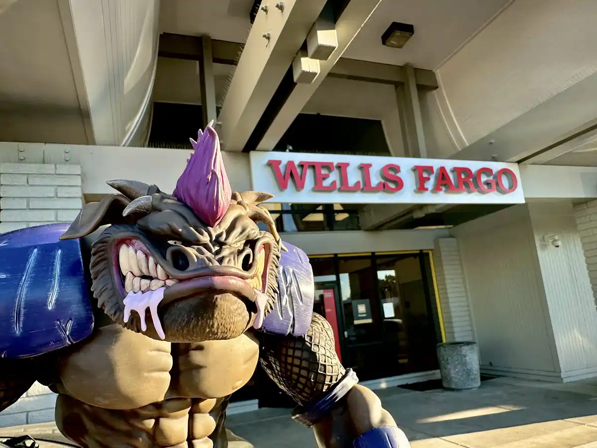 A large, muscular, monstrous statue with a purple mohawk, sharp teeth, and drooling pink substance stands menacingly in…