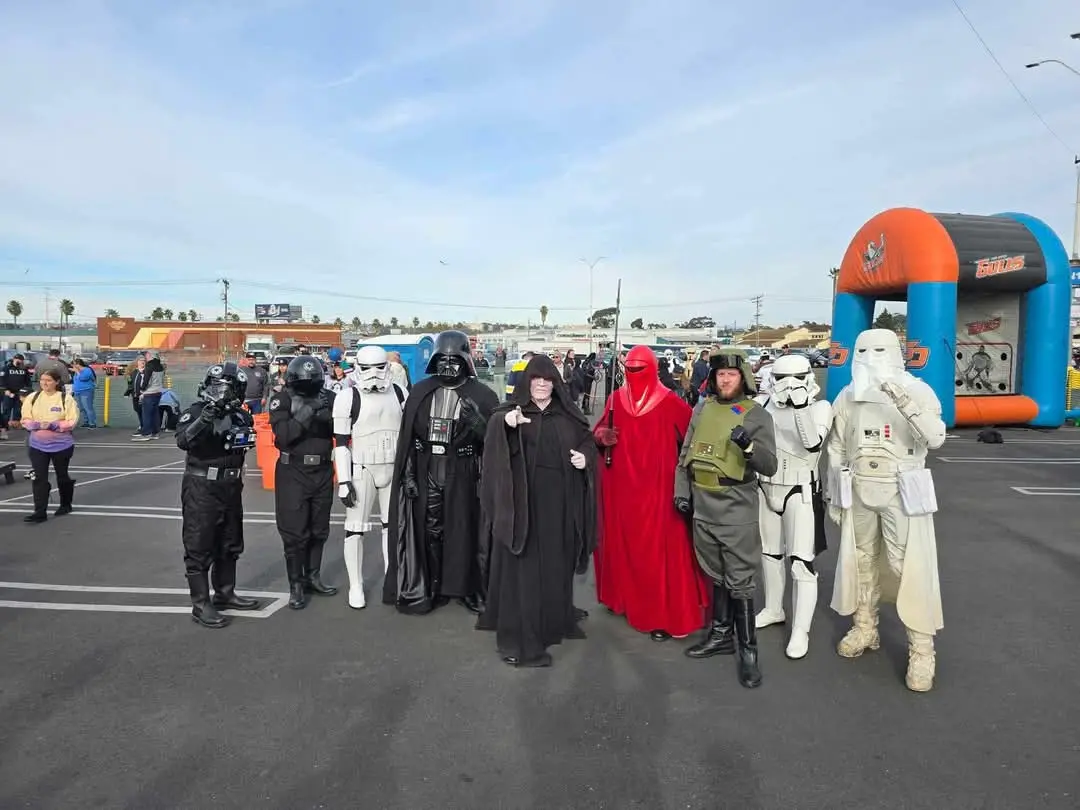 A group of people dressed as Star Wars characters, including Darth Vader, Stormtroopers, and other iconic figures, pose for…