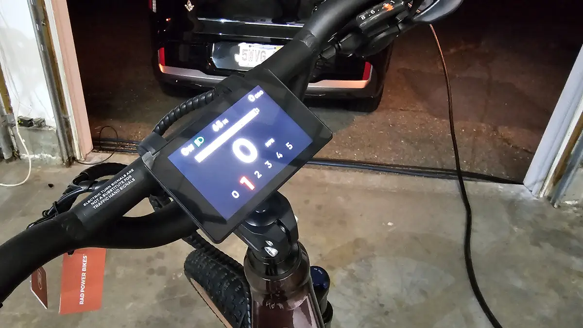 A close-up photo of an electric bike's handlebar-mounted display showing a speed of 0 mph, with a red '1' highlighted below…