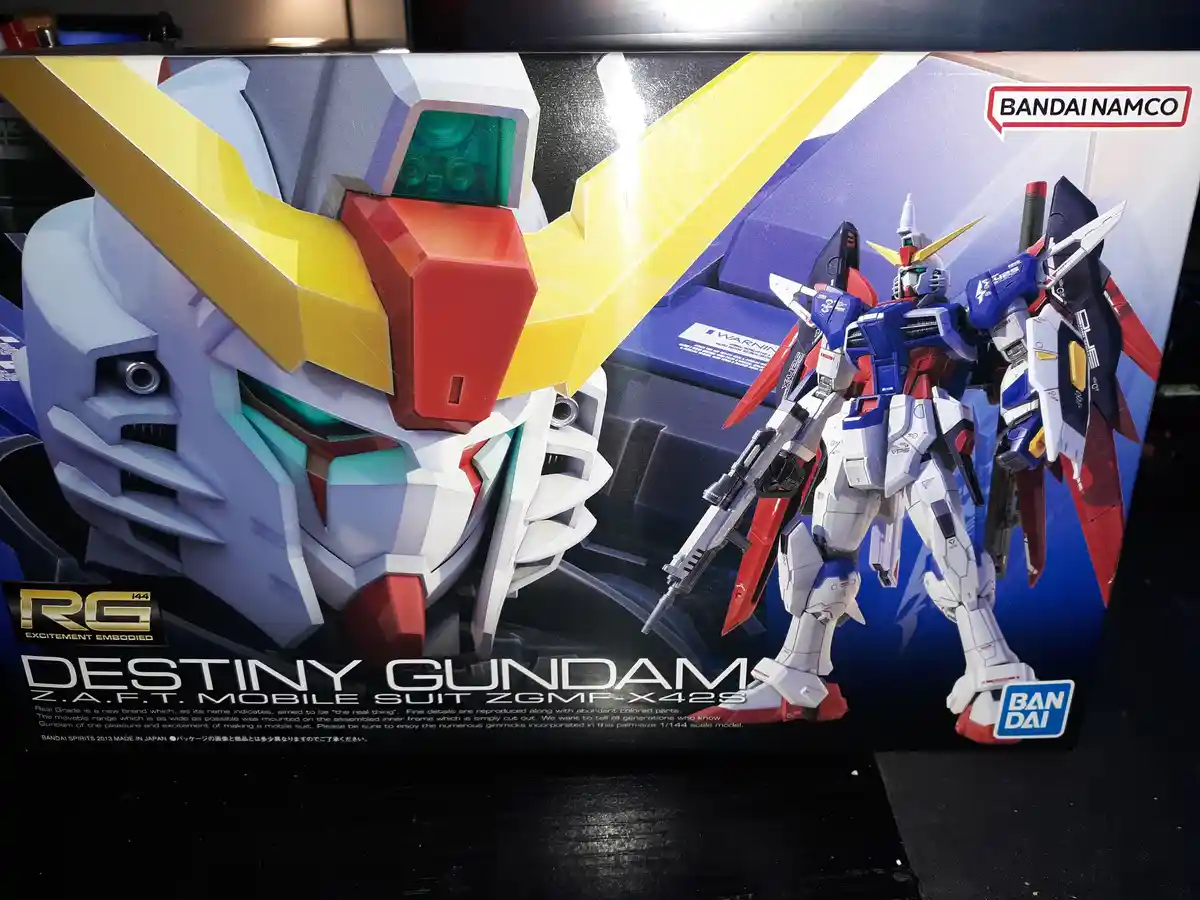 The image shows a Bandai Namco model kit box for the 'Destiny Gundam' mobile suit, featuring a large close-up of its head…