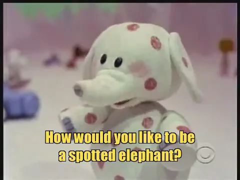 A plush white elephant toy with pink spots is shown in a soft-focus, pastel-colored setting. Yellow text overlaid on the…