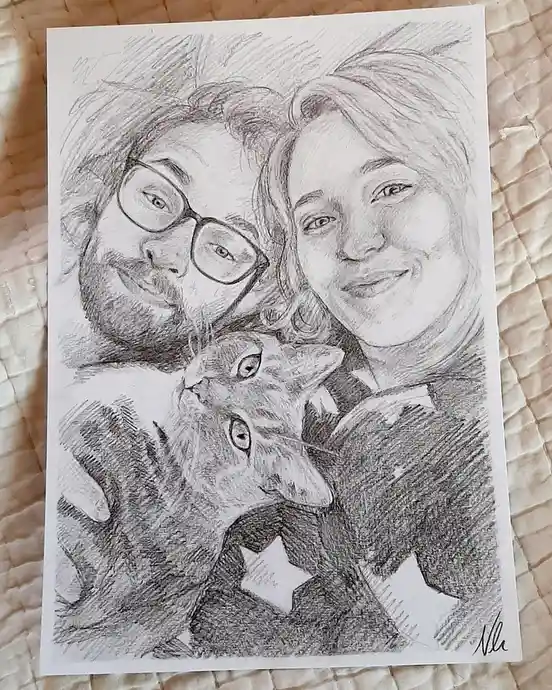 A pencil sketch on paper shows a man with glasses and a beard, a woman with short hair, and a cat nestled between them, all…