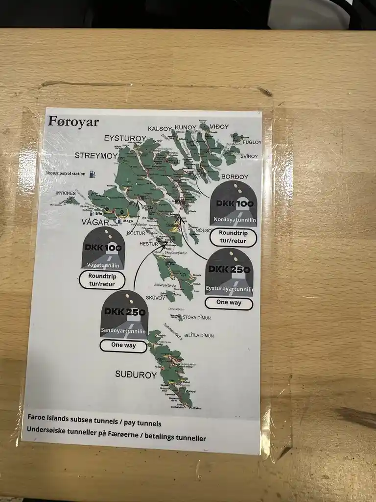 A printed map of the Faroe Islands showing various islands and roads, with four labeled tunnel icons indicating toll prices…