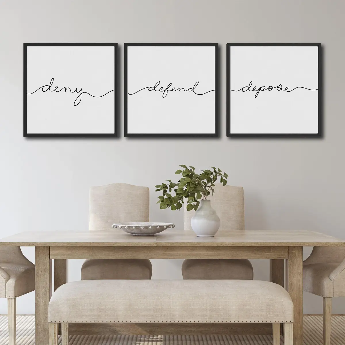 Three framed wall art pieces above a dining table display the words 'deny', 'defend', and 'depose' in elegant cursive…