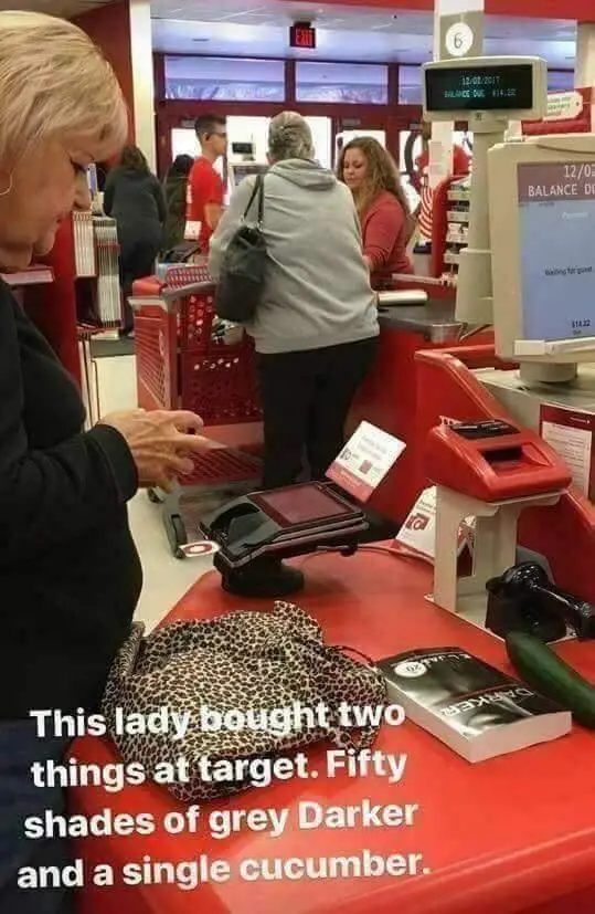 A woman is at a Target checkout counter, looking at her receipt. On the counter, a leopard-print bag, a book titled…