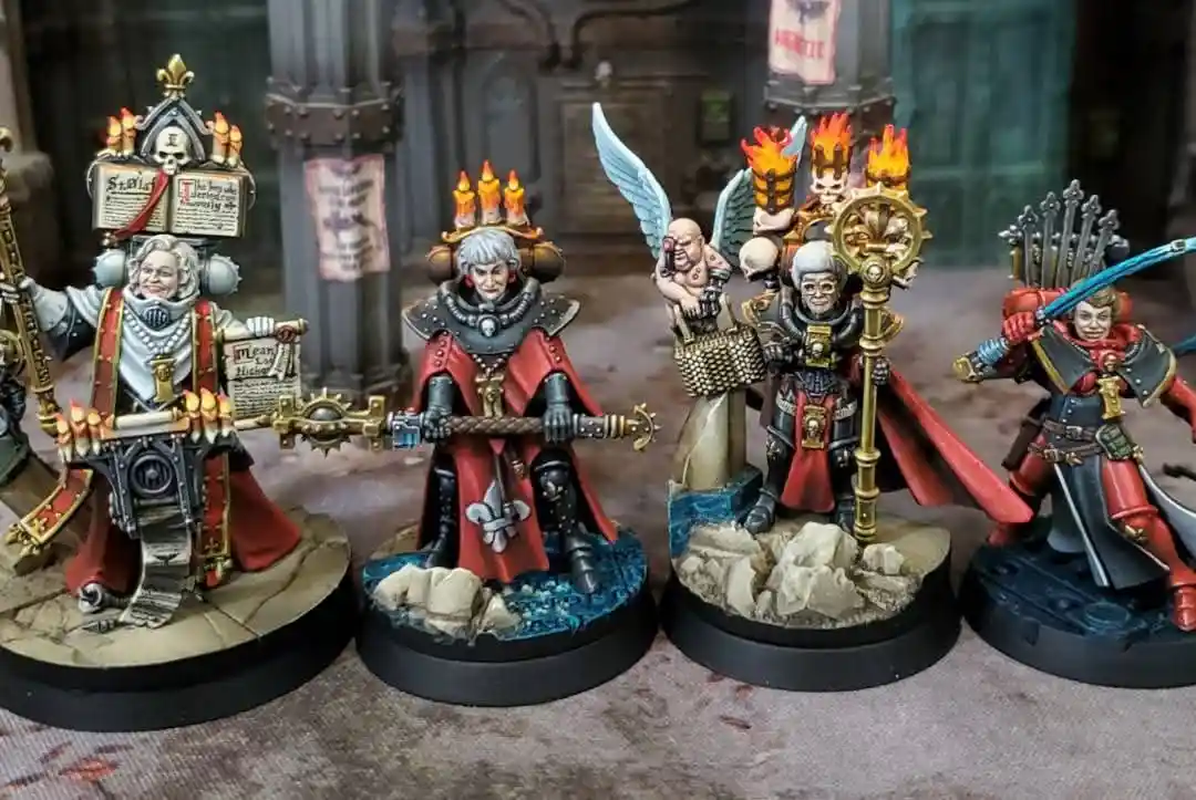 Four intricately painted fantasy miniatures, likely from a tabletop wargame, are displayed in a row. Each figure is heavily…