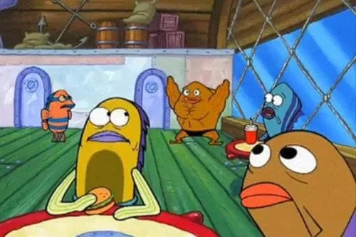 A cartoon scene from 'SpongeBob SquarePants' shows a yellow, wide-eyed character sitting at a table with a burger, looking…